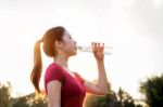 Sporty Woman Drinking Water On Sunlight Stock Photo