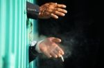 Hand Of Business Man Smoking Cigarette In Jail With Black Backgr Stock Photo