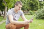 Man Communicate On Social Networks With Tablet Computer In Park Stock Photo