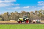 Farmer On Tractor Plowing Sandy Soil In Spring Season Stock Photo