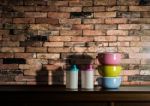 Colorful Tiffin Carrier And Plastic Bottles On Wooden Cupboard W Stock Photo