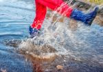 Girl Standing In A Puddle Of Water Splashes Stock Photo