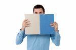 Young Man Hiding His Face With Notebook Stock Photo