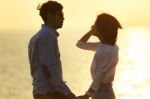 Silhouette Photography Portrait Of Asian Younger Man And Woman Relaxing Vacation At Sea Side Happiness Emotion Against Beautiful Light Of Sun Set Sky Stock Photo