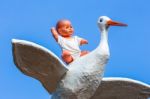 Baby Doll Sitting On Stork With Blue Sky Stock Photo