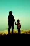 Silhouette Back View Of Mother And Daughter Clasping Hand Togeth Stock Photo