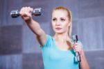 Strong Young Woman Exercising With Dumbbells At The Gym Stock Photo