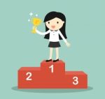 Business Concept, Business Woman Standing On The Winning Podium And Holding Trophy Stock Photo