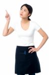 Asian Waitress Pointing And Looking Away Stock Photo