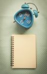 Blue Clock And Blank Notebook Stock Photo