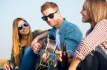 Portrait Of Group Of Friends Playing Guitar And Drinking Beer Stock Photo