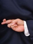 Businessman With Fingers Crossed Stock Photo