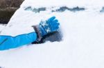 Arm With Glove Removing Snow From Car Window Stock Photo