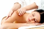 Relaxed Young Woman Enjoying Body Massage Stock Photo