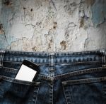 Blue Jeans With Cell Phone In A Pocket Background Stock Photo