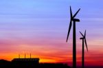 Silhouette Wind Turbine Generator With Factory Emissions Of Carb Stock Photo