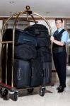 Concierge With Pile Of Bags In Cart Stock Photo