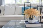 Yellow Flower In Glass Vase And Book  On Glass Table In Living R Stock Photo