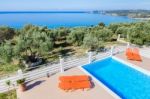 Sunloungers On Terrace With Swimming Pool Near Sea Stock Photo