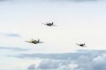 North American P-51d Mustangs And A Spitfire Flying Over Shoreha Stock Photo
