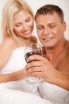 Couple Drinking Wine In Bed Stock Photo
