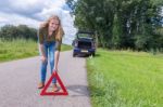 Dutch Woman Placing Warning Triangle On Rural Road Stock Photo