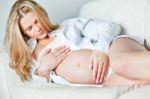 Young Pregnant Woman Resting On Sofa Stock Photo