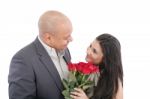 Man Giving A Bouquet Of Red Roses To His Pretty Girlfriend Stock Photo