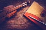 Violin And Notebook With Pen On Grunge Dark Wood Background Stock Photo