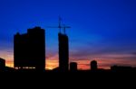Twilight And Silhouette Construction City With Crane On Top Building Stock Photo