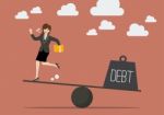 Balancing Between Business Woman And Debt Stock Photo