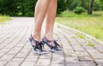 Legs Of A Woman Walking On The Sidewalk Stock Photo