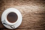 Close Up Overhead View Of A Cup Of Espresso Coffee On A Old Wooden Background. Vintage Style Stock Photo