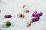 Heap Of Medicine Pills On Cardiogram Grid Paper. Selective Focus Stock Photo