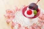 Cherry Cheesecake With Macaron And Measurements Tape Stock Photo
