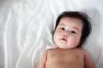 Portrait Of Newborn Baby Lying Down On A Bed, Top View Stock Photo