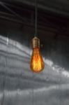 Vintage Hanging Light Bulb Over Gray Room Stock Photo