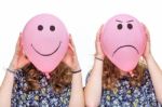 Two Girls Holding Pink Balloons With Facial Expressions For Head Stock Photo