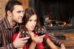 Couple Enjoying Wine Near Fireplace Stock Photo