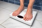 Female Feet On Bathroom Scales Stock Photo