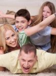 Happy Family Lying On Top Of Each Other Stock Photo