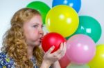Girl Blowing Inflating Colored Balloons Stock Photo