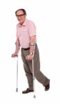 Smiling Elderly Man With Crutches Stock Photo