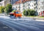 Cleaning Machine Washing The City Asphalt Road With Water Spray Stock Photo