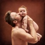 Dad Tenderly Holding A Child In Her Arms Stock Photo