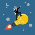 Businessman Astronaut On A Moving Lightbulb Idea Rocket Stock Photo