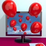 Computer with flying red balloons Stock Photo