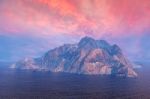 Rock Mountain Island In Ocean Under Dusk Sky Stock Photo