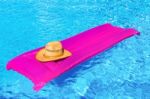 Pink Air Mattrass With Hat In Swimming Pool Stock Photo