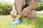Man Tying Shoes On Green Grass Stock Photo